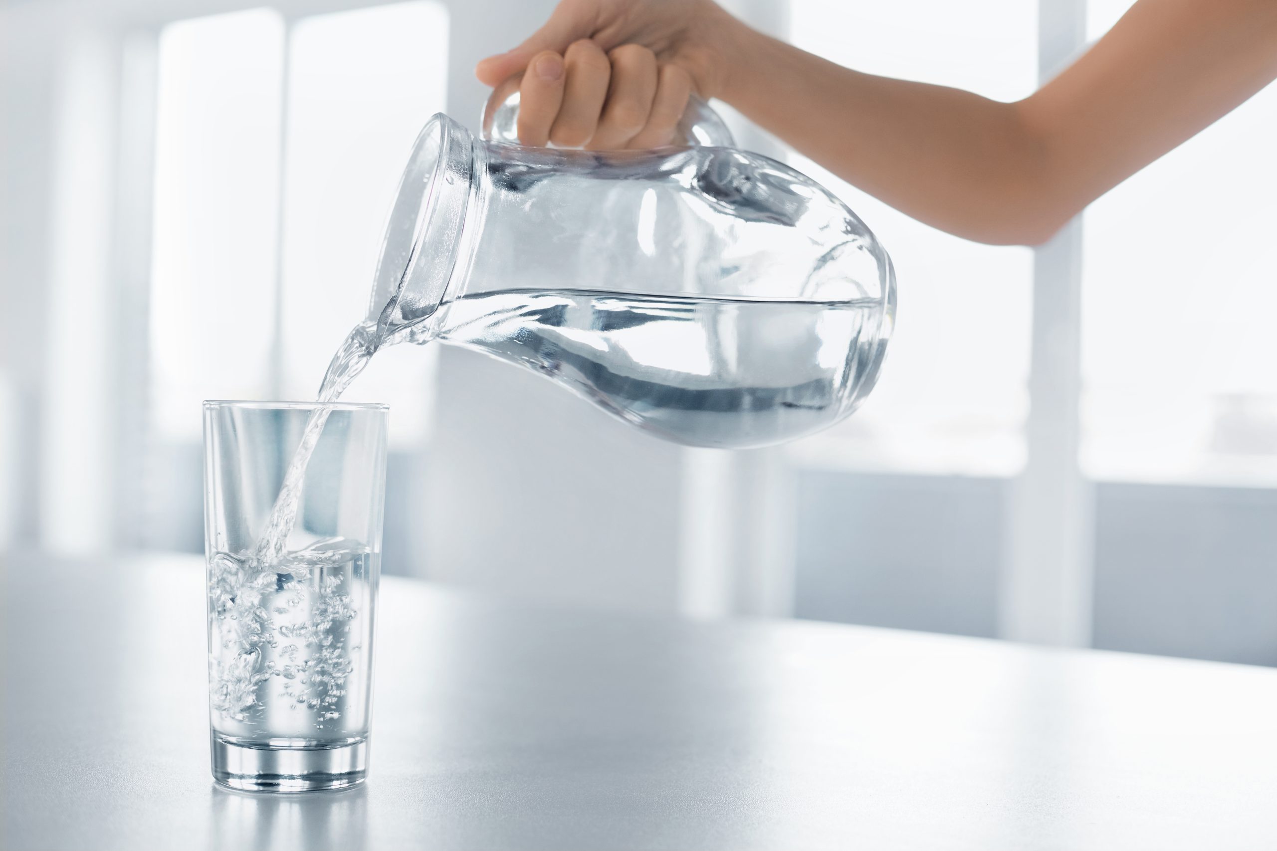 Drink Water. Woman’s Hand Pouring Water From Pitcher Into A Glas